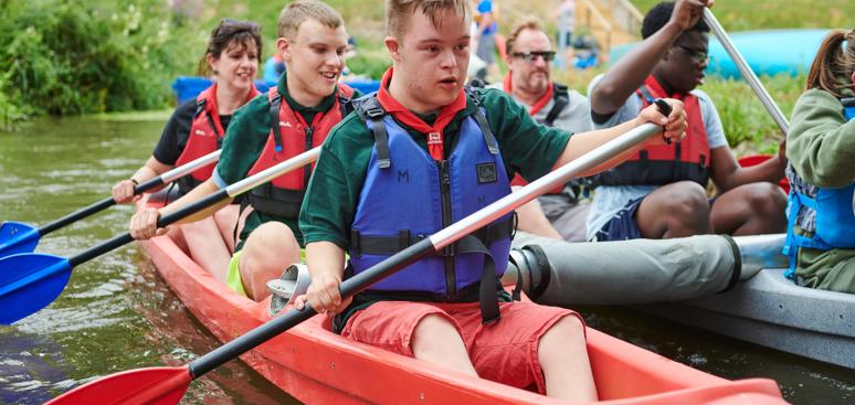 A group of scouts are paddling katakanus and holding paddles min