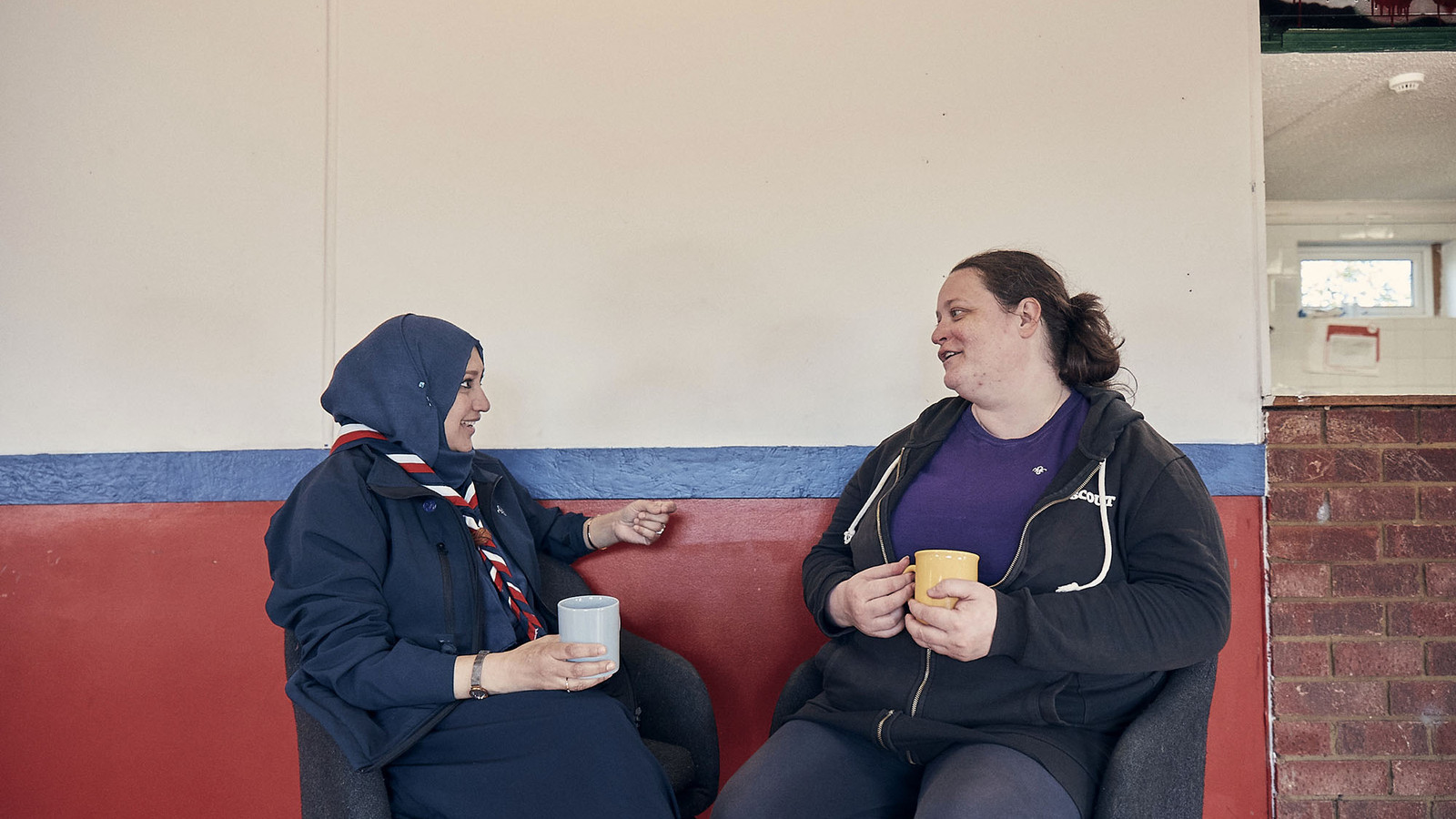 Two female volunteers chatting indoors 5 jpg